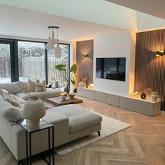 a living room filled with furniture and a flat screen tv mounted on the wall above it