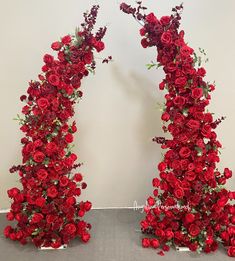 two red roses are arranged in the shape of an arch