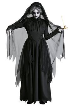 a woman dressed as a ghost holding a lit candle in her hand and wearing a black dress