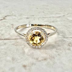 14K Round Citrine Halo Ring - Yellow Gold Citrine Ring - Gemstone Halo Ring - Citrine Promise Ring - November Birthstone Gift -Birthday Gift Beautiful 14 karat yellow gold citrine & diamond halo ring featuring a natural round citrine, the birthstone for November!  The gemstone weighs approximately 1/2 carat, and is haloed by 22 diamond weighing approximately 0.07 carat. G-H SI. Size 7 US. Halo width: 8.23 mm.  > Resizing not included.  This ring can be resized to fit most fingers.  Please contac 14k Gold Yellow Sapphire Ring, Yellow Gold Citrine Gemstone With Center Stone, Yellow Gold Gemstones With Halo Setting, Fine Jewelry Yellow Sapphire Round Ring, Round Yellow Sapphire Ring With Accent Stones, Round Yellow Gold Gemstones With Halo Setting, Elegant Citrine Gemstones For Wedding, Yellow Sapphire Ring With Center Stone, Fine Jewelry Yellow Gemstones For Wedding