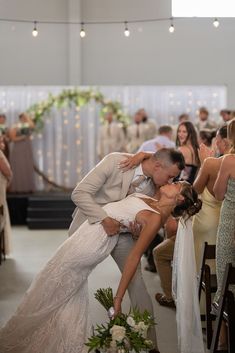 a bride and groom kiss as they walk down the aisle