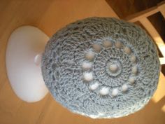 a crocheted object sitting on top of a wooden table