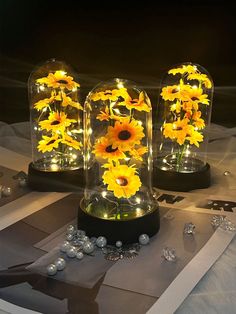 three glass domes with yellow flowers in them