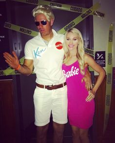 a man and woman are dressed up for a costume contest in front of a wall with caution tape on it