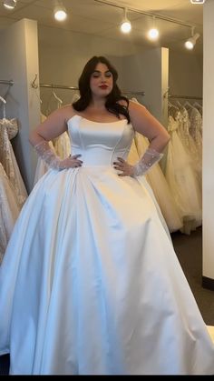 a woman in a white wedding dress posing for the camera