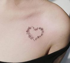 a woman with a heart shaped tattoo on her left shoulder and flowers in the middle