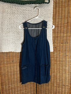 Mid-thigh jean overall dress with the word 'Angel' embroidered on one of front pockets. Sleeveless Cotton Washed Overalls, Sleeveless Cotton Overalls Washed, Dark Wash Buttoned Cotton Denim Jumpsuit, Casual Denim Pinafore Dress With Pockets, Casual Sleeveless Denim Pinafore Dress, Vintage Cotton Denim Dress With Buttons, Casual Bib Front Dress With Pockets, Casual Dresses With Bib Front And Pockets, Sleeveless Denim Shortalls With Pockets