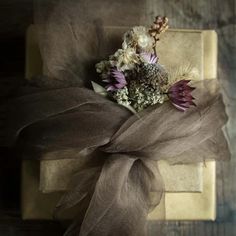 a bunch of flowers sitting on top of a piece of brown paper next to a ribbon