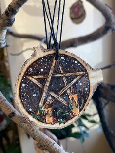 a wooden star ornament hanging from a tree branch