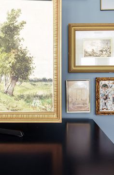 there are many framed pictures on the wall next to each other, including a painting