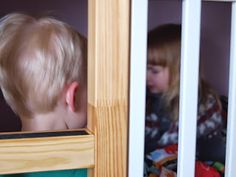 a young boy looking through the window at another child