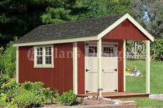 a small red shed sitting on top of a lush green field