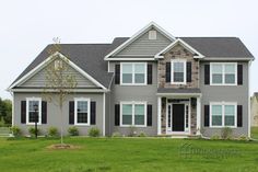 a large gray house with black shutters and windows