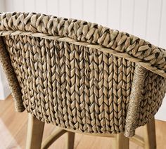 a wicker basket sitting on top of a wooden table next to a white wall