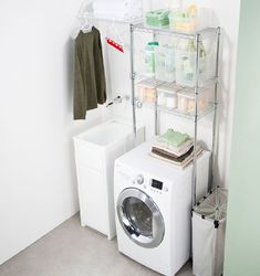 a washer sitting next to a dryer in a room with shelves on the wall