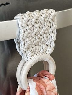 a close up of a towel hanging on the handle of an oven door with rings attached to it