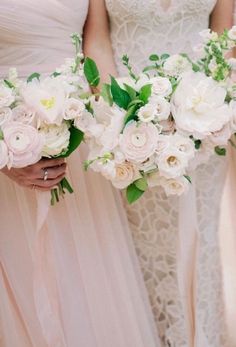 the bridesmaids are holding their bouquets with white and pink flowers on them