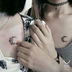 two women with tattoos on their chests and one is holding her hand over the other shoulder