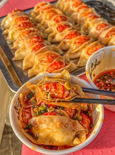 a table topped with bowls and trays filled with food