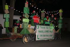 some people are riding in the back of a truck decorated with christmas trees and presents