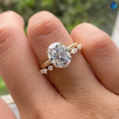 a woman's hand with a diamond ring on top of her finger and an engagement band