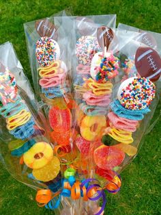 a bouquet of candy and candies in plastic wrappers on the grass with an american football