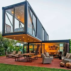 a modern house with glass walls and lots of furniture