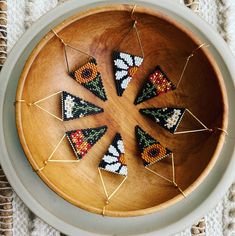 small beaded triangles in a wooden bowl on a table