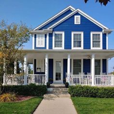 a blue house with white trim and columns