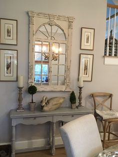 a white table and chairs in a room with pictures on the wall