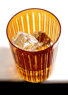 a glass filled with ice sitting on top of a table