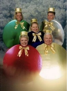 a group of people wearing christmas hats and standing next to each other in front of balloons