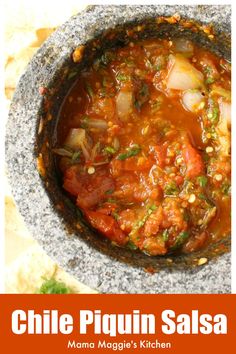 a bowl filled with chili and beans next to tortilla chips on the side