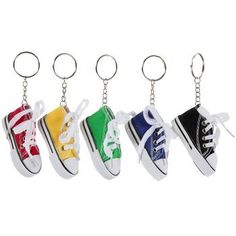 four pairs of shoes are hanging from a keychain with the colors of each shoe