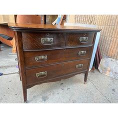 an old wooden dresser sitting on top of a sidewalk