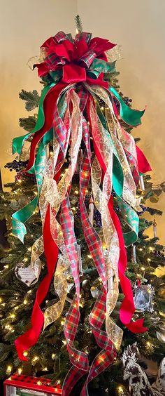 a christmas tree decorated with ribbons and lights