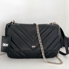 Covered In Eye-Catching Quilting, Dkny's Polished Veronica Bag Has A Timeless Appeal That's Modernized By A Minimalist Silhouette. Quilted Leather Crossbody Bag From Dkny Featuring Black, Lambskin, Quilted Finish, Silver-Tone Logo Lettering, Foldover Top With Magnetic Fastening, Leather And Chain-Link Shoulder Strap, Logo-Print Lining, Main Compartment, Internal Logo Patch And Internal Zip-Fastening Pocket. Dimensions: 9 3/4" Length X 6 3/4" Height X 3.5 Depth Drop: 12.5" (Handles) & 23" (Strap) Chic Rectangular Bags With Silver-tone Logo Plaque, Chic Black Bag With Silver-tone Logo Plaque, Chic Bags With Silver-tone Logo Plaque For Everyday Use, Modern Shoulder Bag With Silver-tone Logo Plaque, Shoulder Bag With Silver-tone Logo Plaque For Everyday Use, Silver-tone Logo Plaque Shoulder Bag, Chic Evening Bag With Silver-tone Logo Plaque, Dkny Bag, Red Leather Handbags