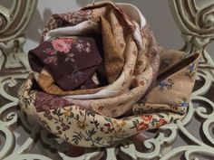 a close up of a scarf on top of a metal chair with floral print fabric