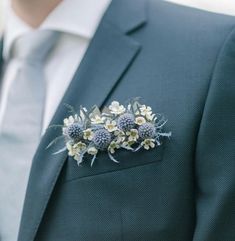 a man wearing a suit and tie with flowers on the lapel flower brooch