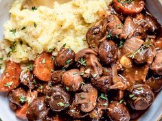 a white plate topped with mashed potatoes and mushrooms