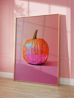 an orange painted pumpkin sitting on top of a pink floor in front of a pink wall