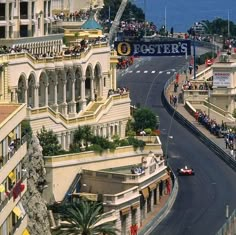 an aerial view of a race track with cars driving on it and people watching from the top