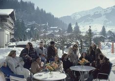 a group of people sitting around a table in the snow