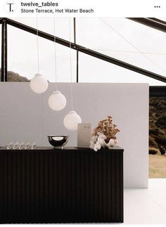 an image of a table with lights hanging from it's sides and vases on top