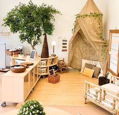 a living room filled with furniture and a tree in the corner on top of it