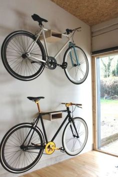 two bikes mounted to the wall in a room