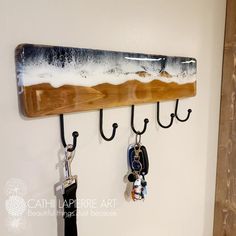 a coat rack with several key hooks hanging from it's sides and a wooden board mounted to the wall