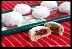 some food is laying out on a red and white table cloth next to a green tray