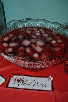 a glass bowl filled with ice cubes on top of a red cloth covered table