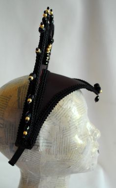 This vampire style gothic headdress is covered with taffeta and embellished with black breaded trimming all around the edges.It is further decorated with black beaded details that create a halo effect. The piece is completed with a black crystal handmade element placed at the center in order to create even more visual interest! Choose between burgundy (pictured), black or dark blue as well as having total black crystal beading or a combination of black crystals and golden pearls (pictured). The Gothic Headdress, Gothic Headpiece, Vampire Style, Queen Of Darkness, Elizabethan Collar, Halo Effect, Halloween Gothic, Style Gothic, Total Black